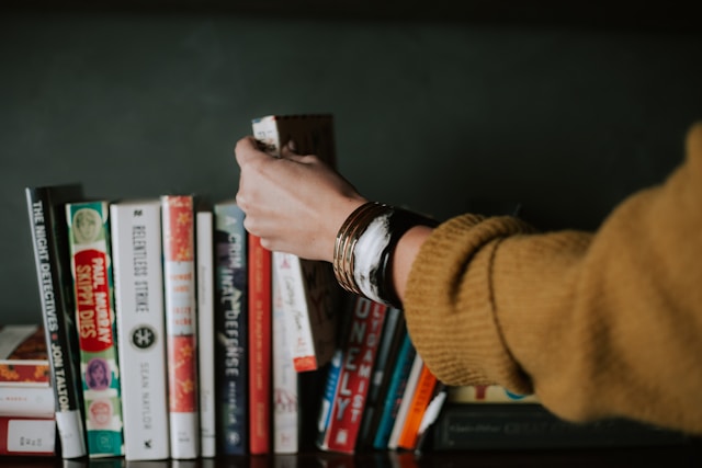 choosing book from bookshelf