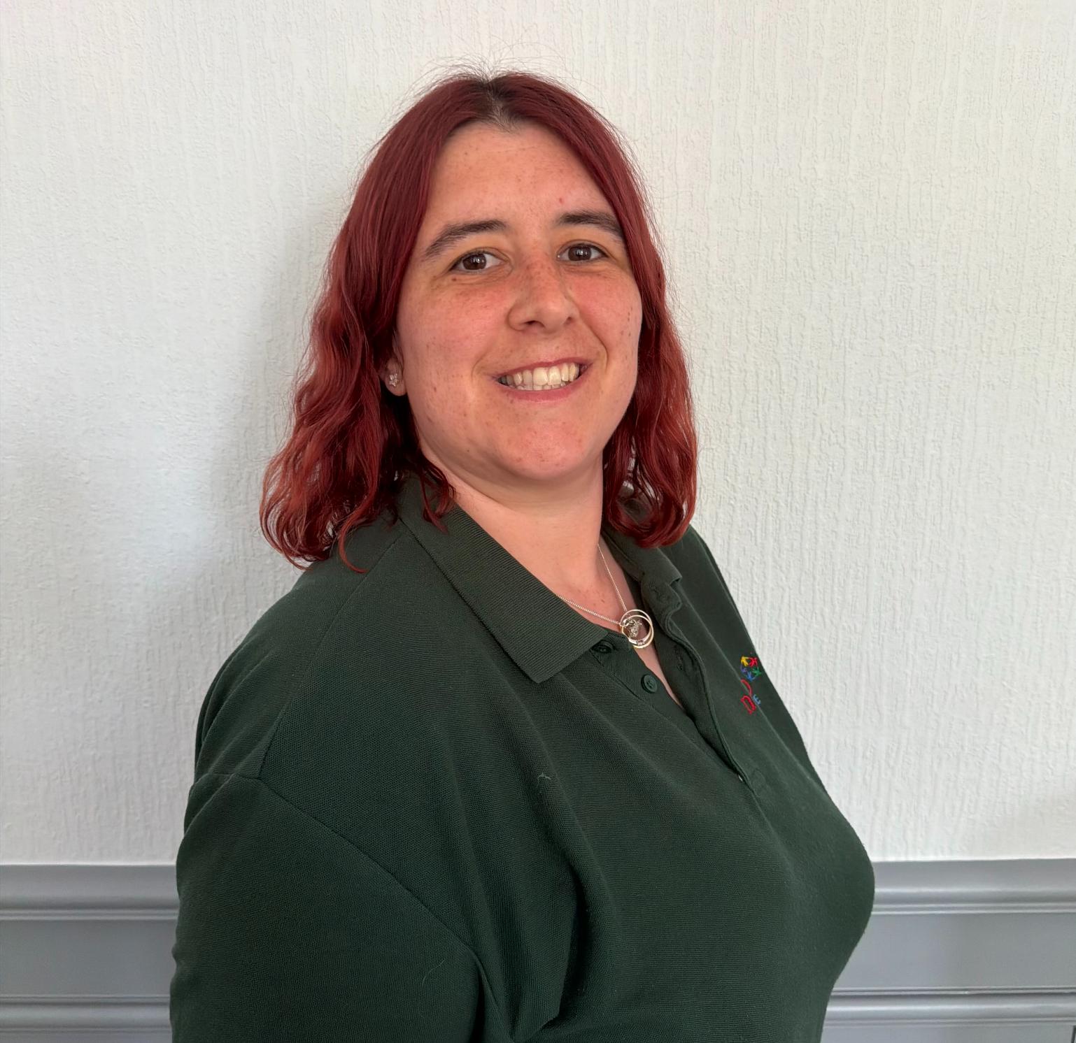 laundry assistant wearing a green polo shirt